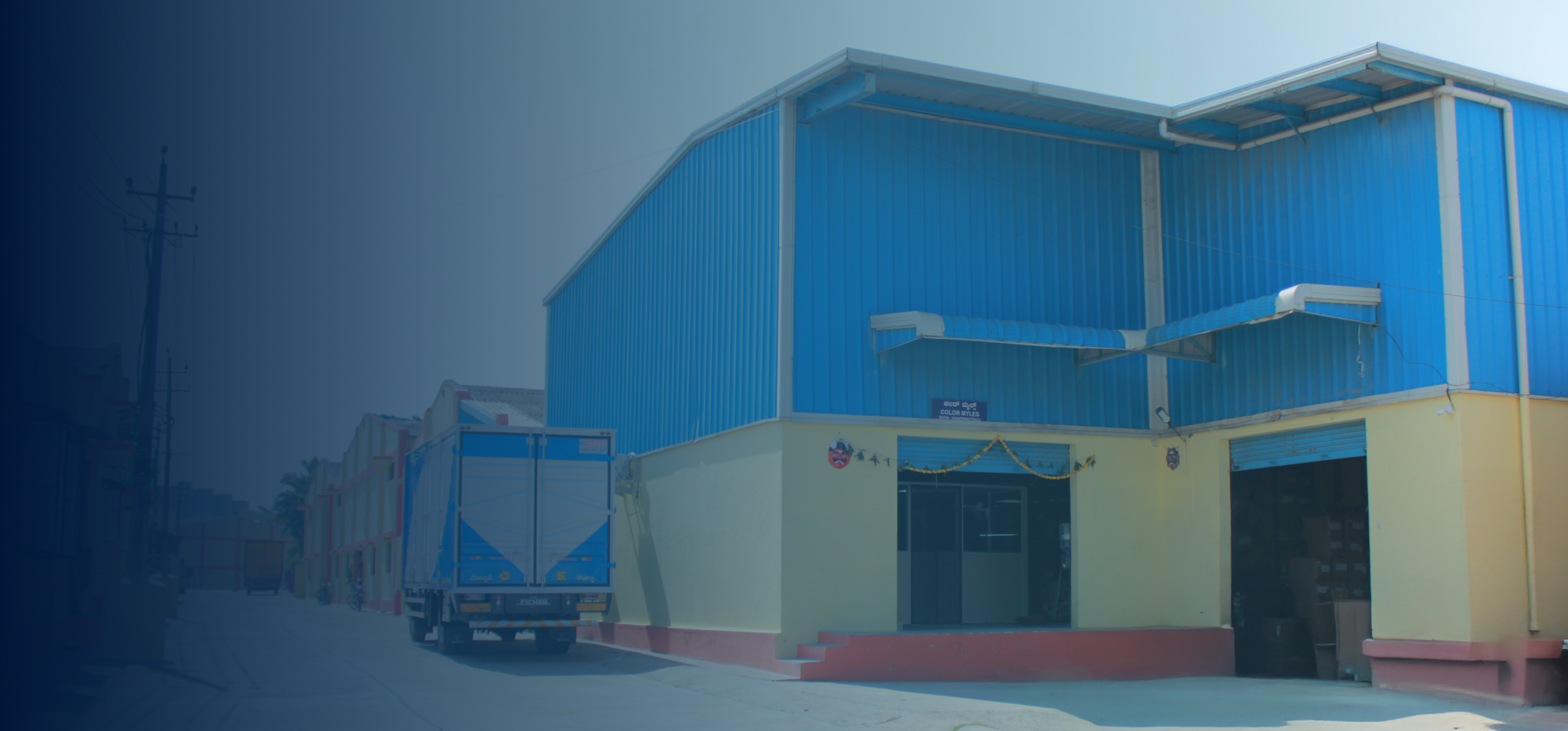 Blue and yellow building with a truck in front on a foggy day