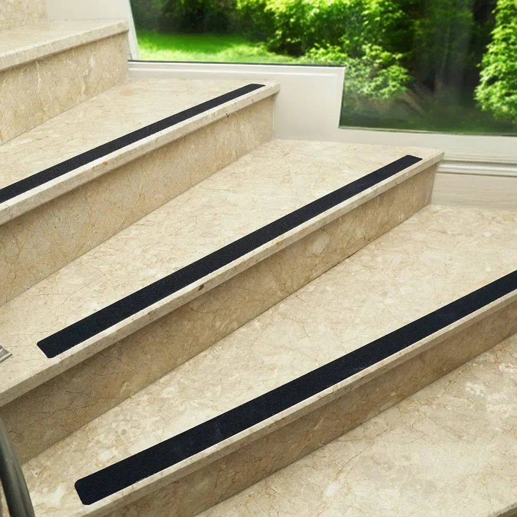 LifeKrafts black anti-skid tape strips installed on marble stair edges for added traction