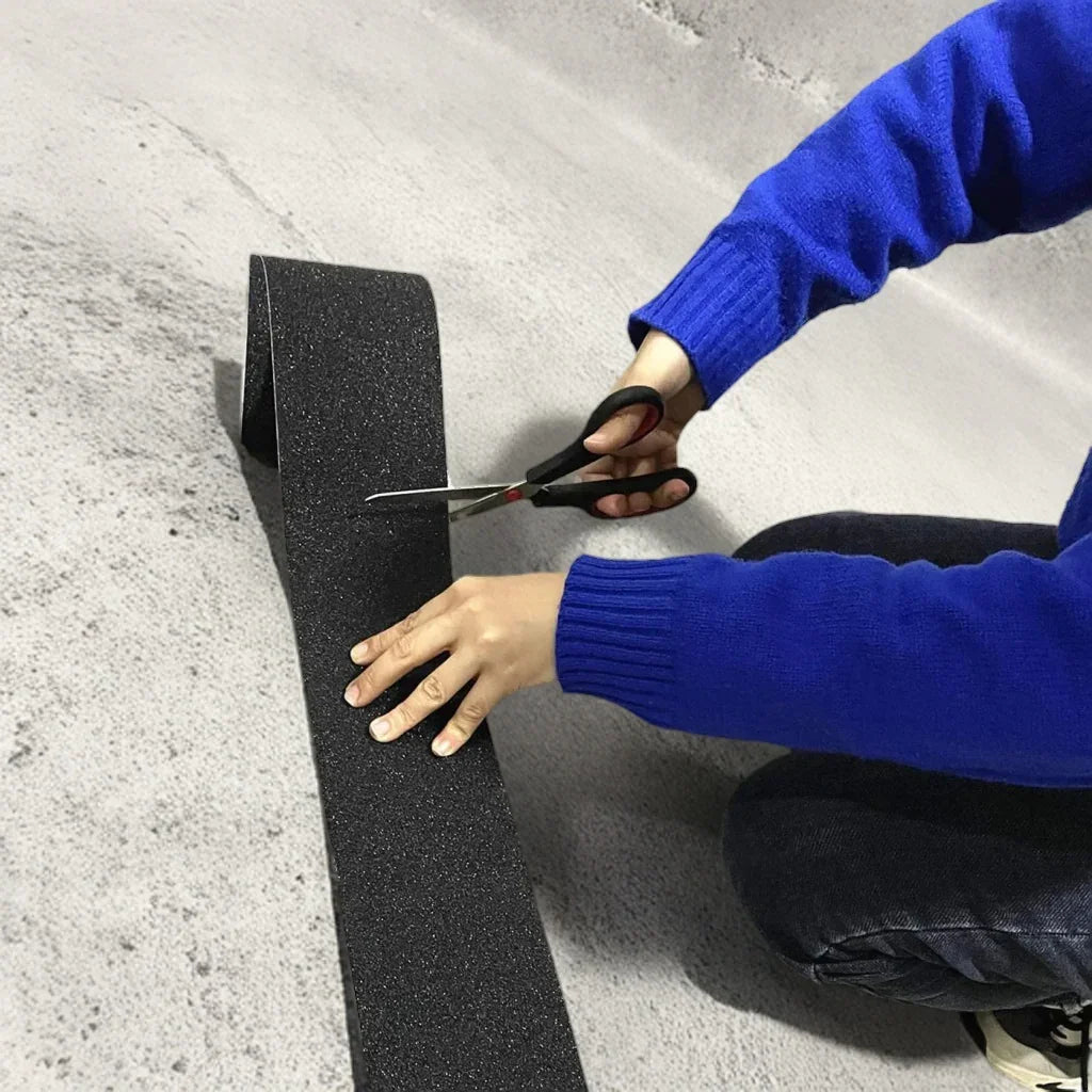 Cutting LifeKrafts black anti-skid tape to required length before installation