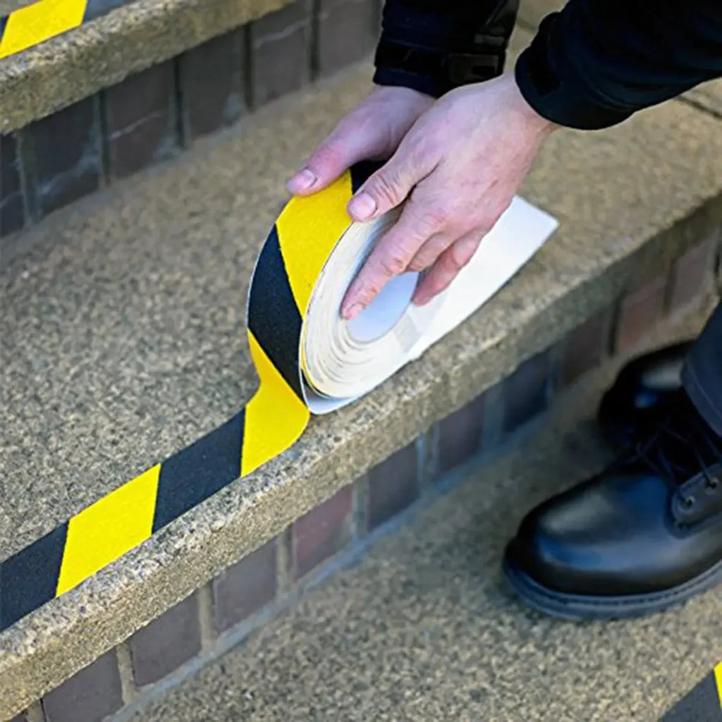 Installing LifeKrafts yellow and black anti-skid safety tape on outdoor stair edges