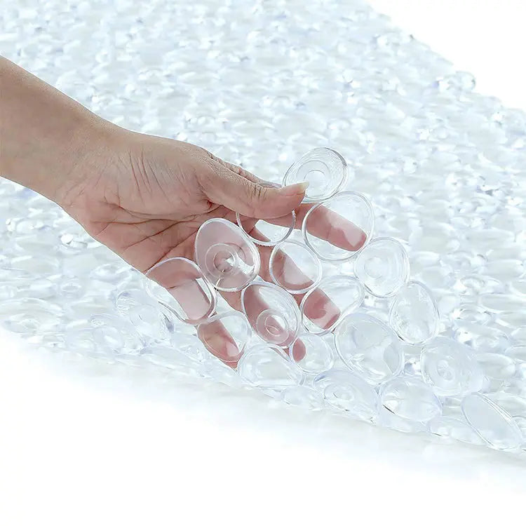 Transparent stone pebble anti-slip bath mat close-up showing suction cups for floor grip