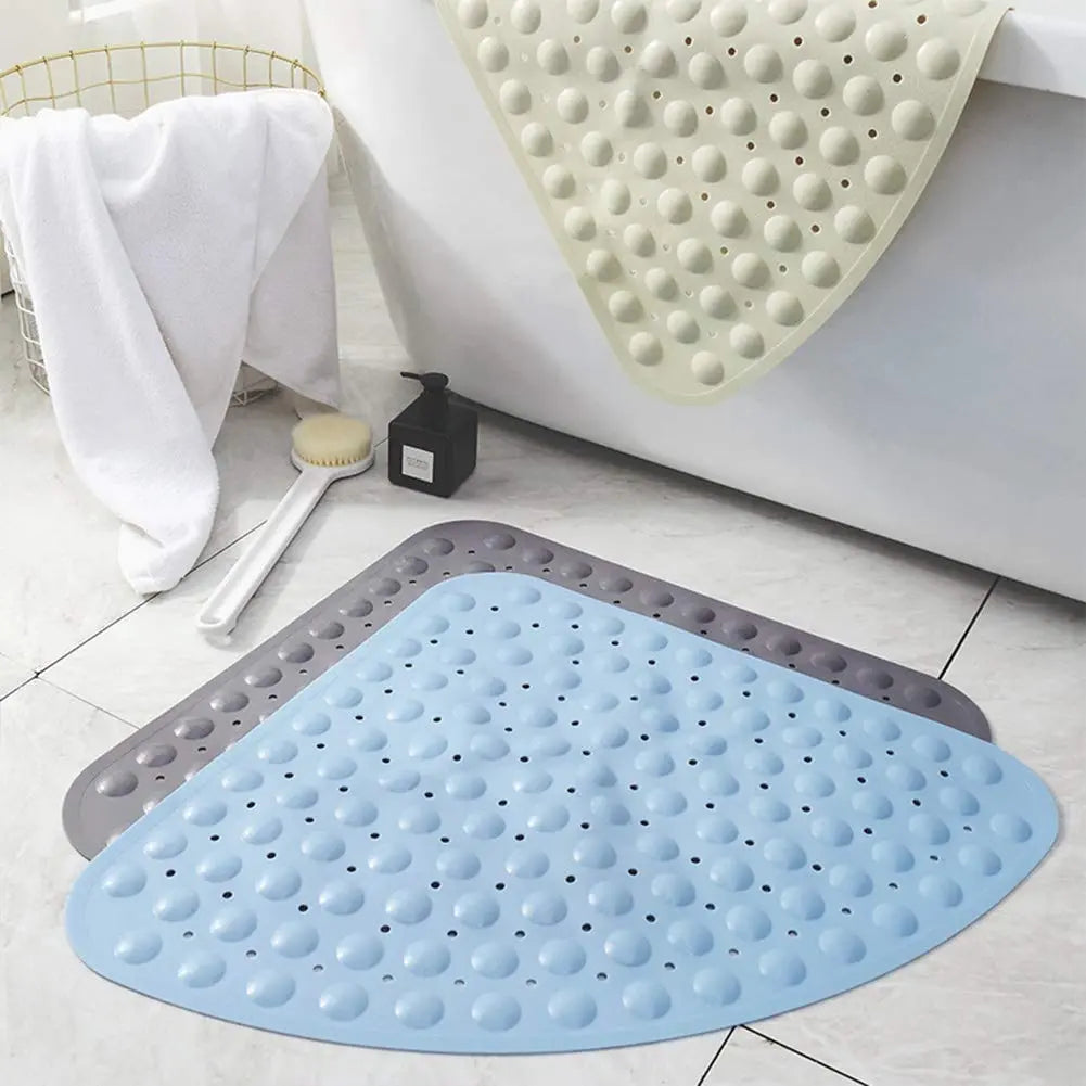 Blue triangle soft pebble anti-slip bath mat placed on bathroom floor beside bathtub