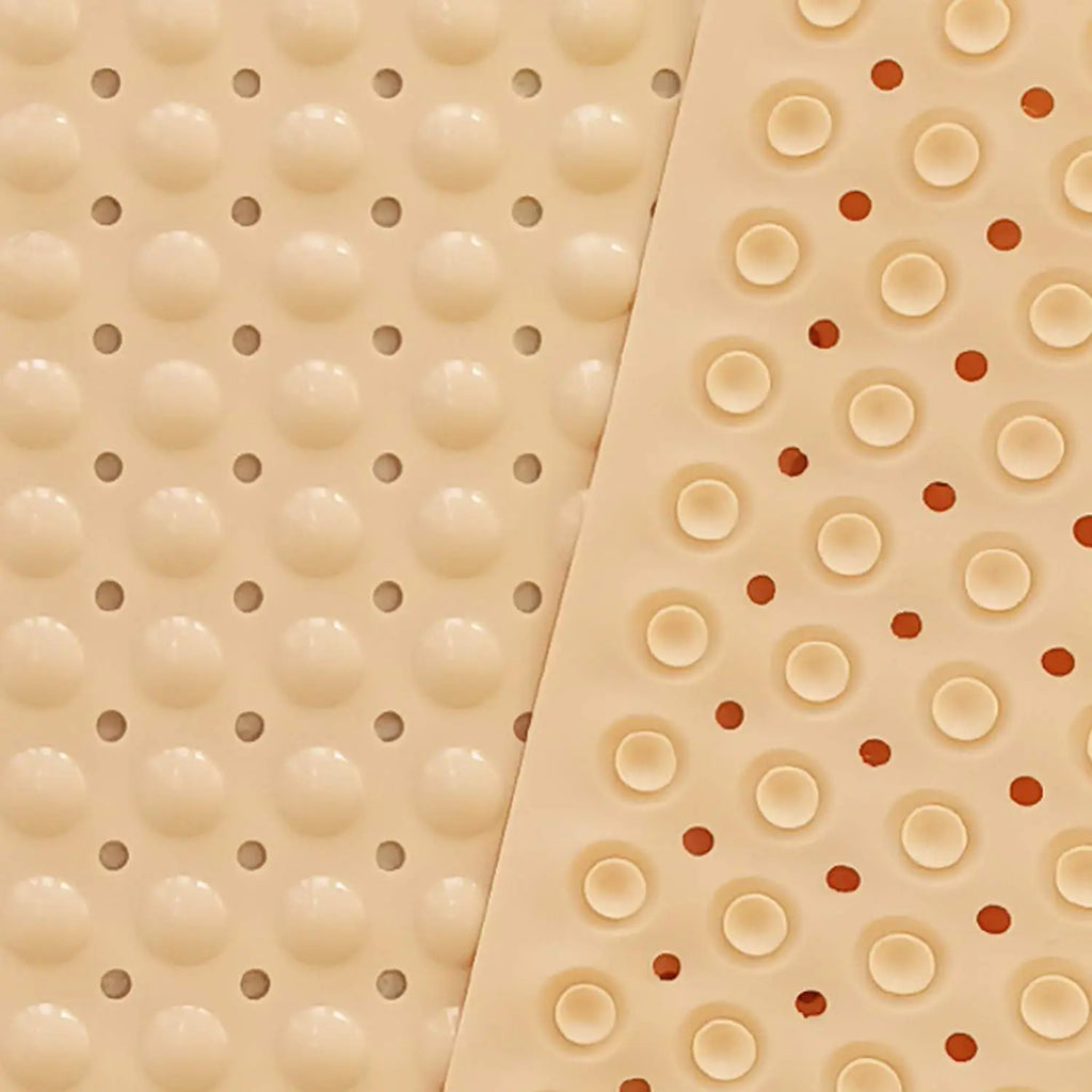 Cream Soft Pebble bath mat showing raised surface drainage holes and suction cup underside
