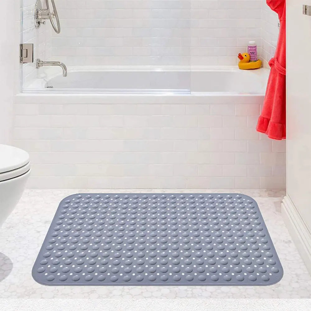 Grey Soft Pebble anti-slip bath mat on bathroom floor beside bathtub
