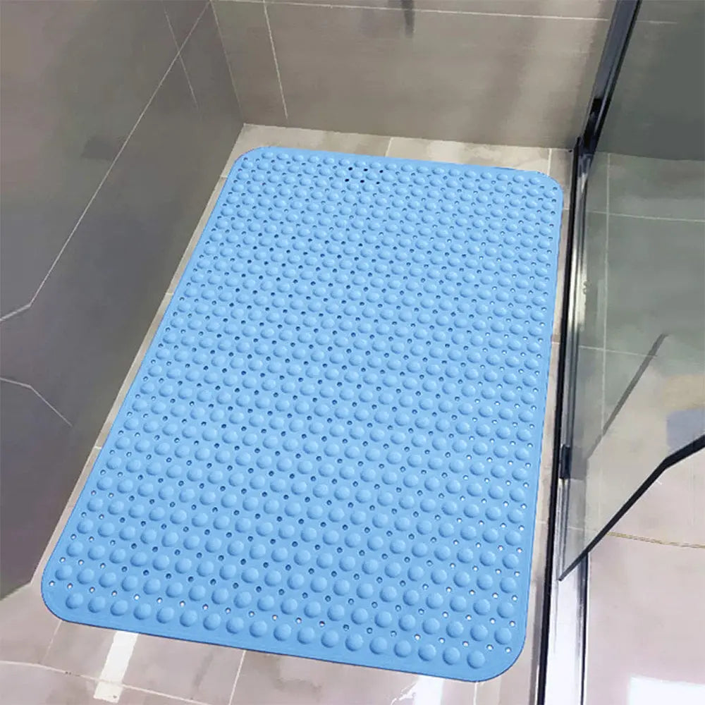 Blue Soft Pebble anti-slip bath mat with drainage holes installed on tiled shower floor