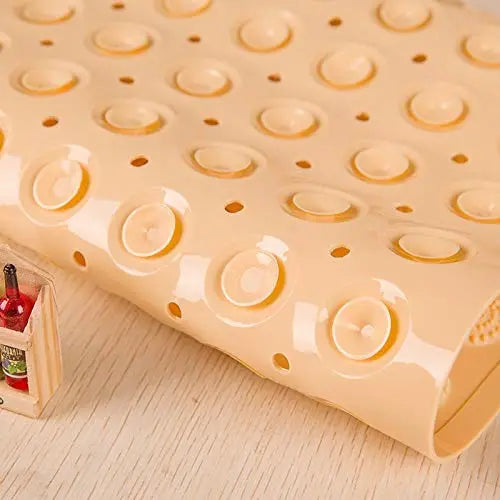 Close-up of cream Accu Pebble bath mat showing drainage holes and suction cup underside
