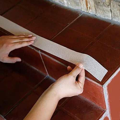 White anti-skid tape being applied to tiled stairs for added surface traction