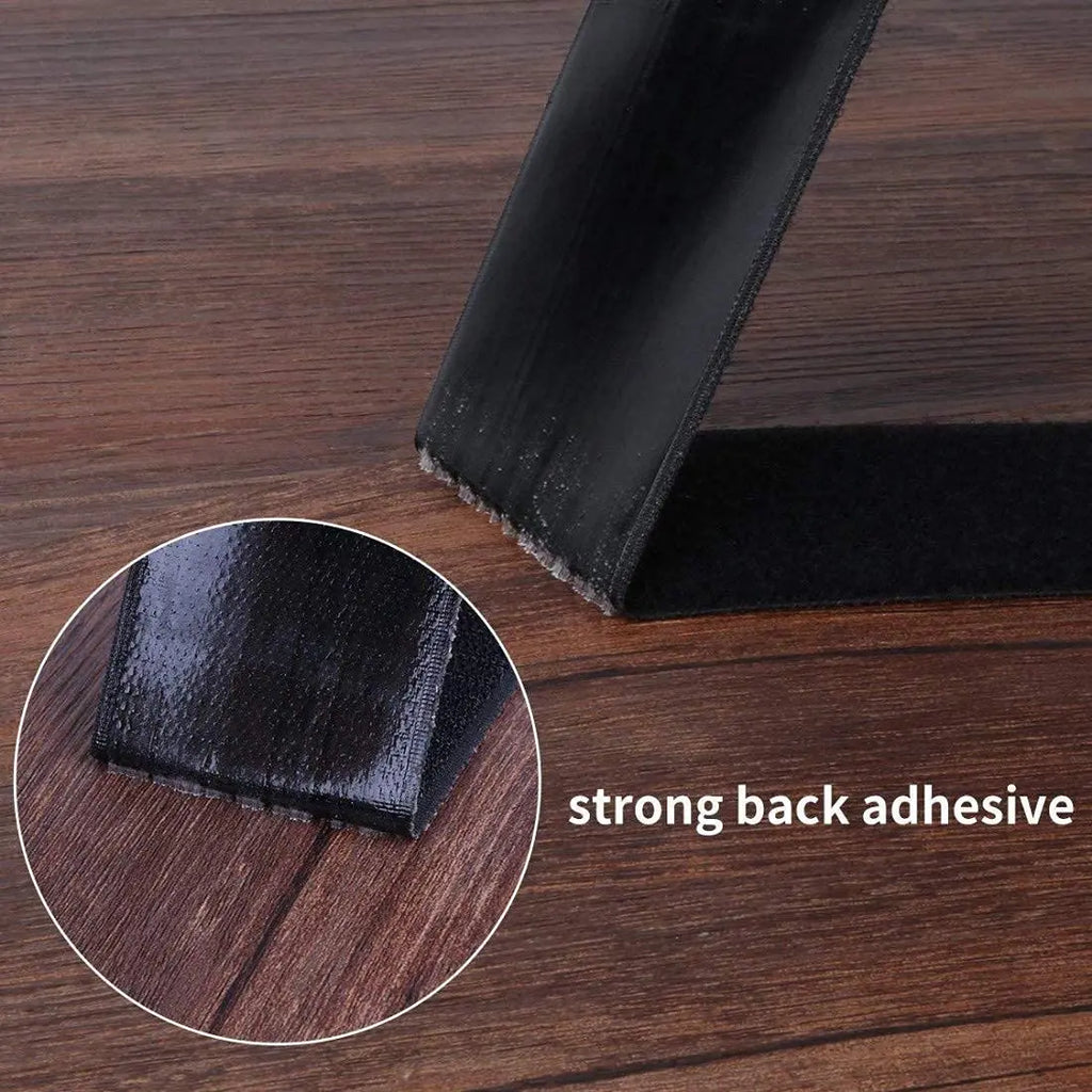Black self-adhesive hook and loop tape showing adhesive backing on wood surface